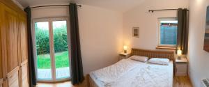 ein Schlafzimmer mit einem Bett und einem großen Fenster in der Unterkunft Ferienwohnung Blaue Sonne Devin in Stralsund