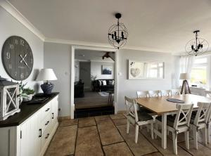 a kitchen and dining room with a table and a clock at Chesil Watch in Abbotsbury