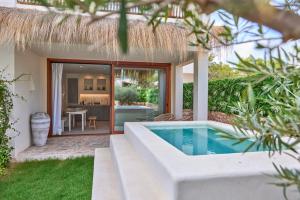 a villa with a swimming pool and a house at Mar Suites Formentera by Universal Beach Hotels in Es Pujols