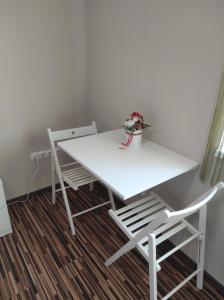 una mesa blanca y 2 sillas en una habitación en BarBen Apartman, en Mórahalom