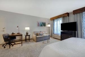 Habitación de hotel con cama, escritorio y TV. en Hampton Inn & Suites San Luis Obispo, en San Luis Obispo