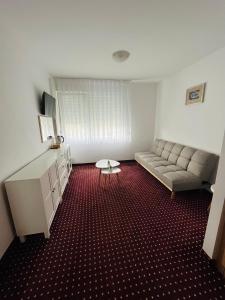 uma sala de estar com um sofá e uma mesa em Hotel Panonija em Sisak