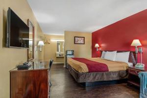 a hotel room with a bed with a red wall at Econo Lodge Union City - Atlanta South in Union City