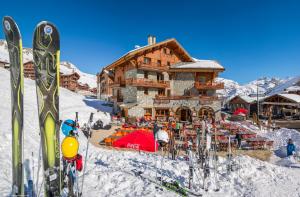 domek narciarski na śniegu z nartami przed w obiekcie Résidences Village Montana by Les Etincelles w mieście Tignes