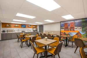 une salle à manger avec des tables et des chaises ainsi qu'une cuisine dans l'établissement Clarion Pointe Sevierville-Pigeon Forge, à Sevierville