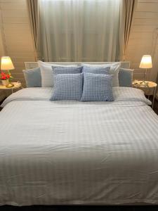 Elle comprend un grand lit avec des oreillers bleus et blancs. dans l'établissement บ้านแสนรัก Casa Dolce Casa, Prakhon Chai, à Prakhon Chai