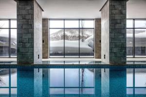 una piscina en un edificio con ventanas y nieve en Park Hyatt Niseko Hanazono, en Niseko