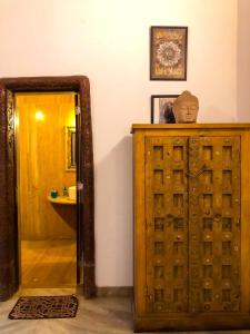 uma casa de banho com uma porta de madeira e um espelho em Siolim Villa Goa 3 bhk em Siolim