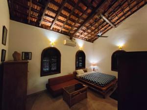 uma sala de estar com um sofá e uma cama em Siolim Villa Goa 3 bhk em Siolim