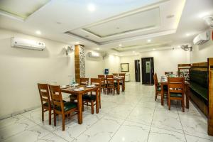 a dining room with wooden tables and chairs at Hotel Wisteria Zirakpur - Main Highway Hotel in Zirakpur