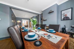 ein Esszimmer mit einem Holztisch und Stühlen in der Unterkunft Stunning 3BR House w Garden & Parking in Richmond in Kew Gardens