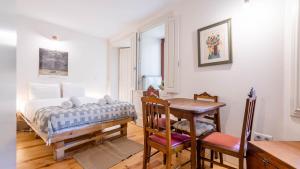 1 dormitorio con cama, escritorio y mesa en Taipas Tranquility: Cozy T0 by LovelyStay, en Oporto