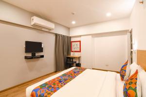 a bedroom with a bed and a flat screen tv at FabHotel Sayeeda International in Kolkata