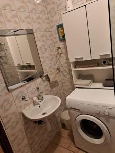 ein Badezimmer mit einer Waschmaschine und einem Waschbecken in der Unterkunft Apartman Zuki in Zagreb