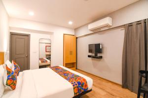 コルカタにあるFabHotel Sayeeda Internationalのベッドとテレビ付きのホテルルーム