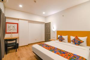 コルカタにあるFabHotel Sayeeda Internationalのベッドとデスクが備わるホテルルームです。