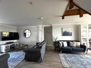 a living room with two couches and a tv at Chesil Watch in Abbotsbury