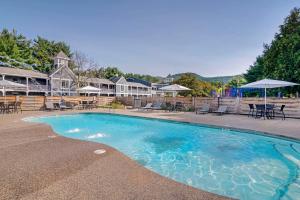 a swimming pool with chairs and tables and a building at Green Granite Inn, Ascend Hotel Collection in North Conway