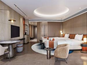 a hotel room with a bed and a flat screen tv at Hilton Huzhou Nanxun in Huzhou