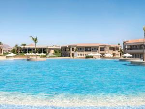 a large pool of blue water in front of buildings at Rixos Golf Villas And Suites Sharm El Sheikh in Sharm El Sheikh