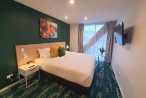 Un dormitorio con una gran cama blanca y una ventana en La Quinta by Wyndham Ellerslie Auckland en Auckland