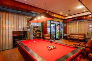 a pool table in a living room with a pool at Lamai Hotel in Patong Beach