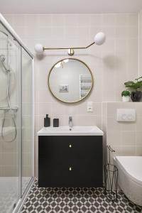 a bathroom with a sink and a mirror at Ogrody Pieniawskie Apartament Paryski in Polanica-Zdrój