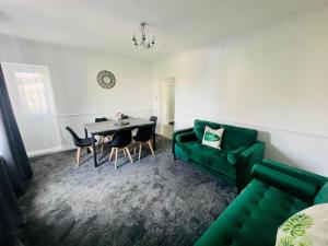 ein Wohnzimmer mit einem grünen Sofa und einem Tisch in der Unterkunft Mitchell Apartment by Klass Living Coatbridge in Coatbridge