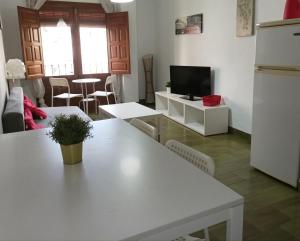 sala de estar con mesa blanca y TV en Apartamento En Centro Historico, en Granada