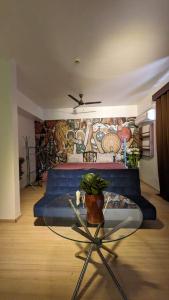 a room with a couch and a table with a mural at The Nest Lucknow in Lucknow