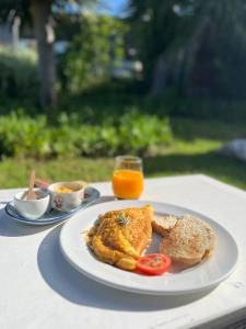 - une assiette de nourriture avec du pain grillé et du jus d'orange sur une table dans l'établissement The Farmhouse Palm Tree Cabin, à Stellenbosch