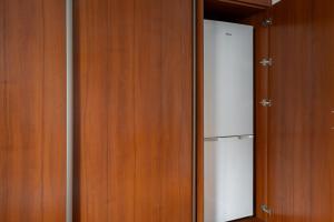 a closet with a refrigerator and wooden walls at Park Praski Standard Studio in Warsaw