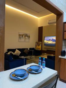 a living room with a table with blue dishes on it at شقه غرفتين وصاله دخول ذاتي (حي النرجس) in Riyadh