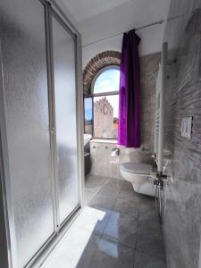 a bathroom with a shower and a toilet and a sink at Casa Viola - Al Centro in Taormina