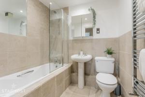 ein Bad mit einem WC, einem Waschbecken und einer Dusche in der Unterkunft Modern 2 bed apartment at Imperial Court, Newbury in Newbury