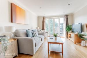 Modern 2 bed apartment at Imperial Court, Newbury في نيوبري: غرفة معيشة مع أريكة وتلفزيون