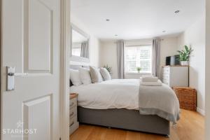 ein weißes Schlafzimmer mit einem großen Bett mit weißen Kissen in der Unterkunft Modern 2 bed apartment at Imperial Court, Newbury in Newbury