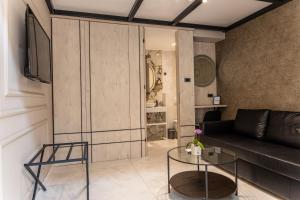 a living room with a couch and a table at Garni Boutique Hotel Arta in Novi Sad