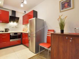 a kitchen with red cabinets and a stainless steel refrigerator at Karpacz wczasy in Karpacz