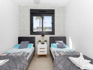 two twin beds in a room with a window at Lovely first floor apartment, heating pool ! in Playa Flamenca +31 photos