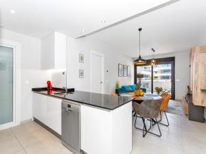 a kitchen with white cabinets and a table in a room at Lovely first floor apartment, heating pool ! in Playa Flamenca