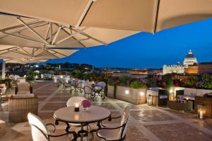 a rooftop patio with tables and chairs and a view of the city at Orange Garden B&B in Rome