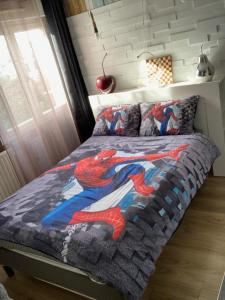 um quarto com uma colcha de homem-aranha numa cama em Cosy apartment Disneyland Paris en face de la gare RER val d'Europe em Serris