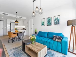 a living room with a blue couch and a table at Lovely first floor apartment, heating pool ! in Playa Flamenca