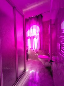 La salle de bains rose est pourvue de toilettes et d'une douche. dans l'établissement Casa Viola - Al Centro, à Taormine