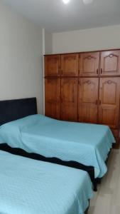 2 camas en un dormitorio con armarios de madera en Apartamento Copacabana, en Río de Janeiro
