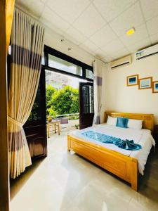 a bedroom with a bed and a large window at SHARK HOSTEL in Hue +29 photos
