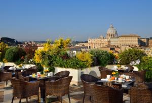 een patio met tafels en stoelen en uitzicht op de stad bij Orange Garden B&B in Rome