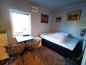 a bedroom with a bed and a desk and chairs at Abisko Guesthouse & Activities in Abisko