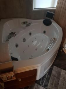 baño con bañera blanca y ventana en H15, Sauna- en Wellnesschalet geschikt voor 2 personen en Epe